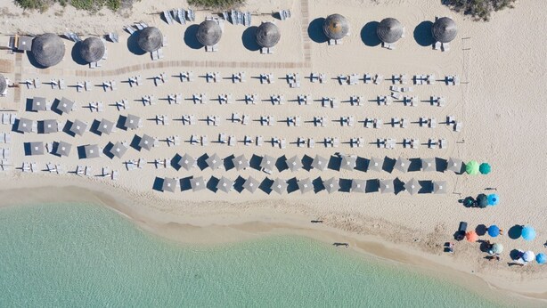 An aerial view of a beach resort with rows of beach umbrellas and lounge chairs, a sandy beach, and a clear blue sea. - Vidamarina - Camere al Mare (Torre Castiglione)