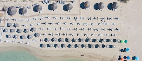 Playa en los alrededores, playa de arena blanca y camastros