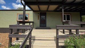 A building with a covered entrance, a wooden walkway leading to it, and a clear sky above. - Ranch Retreat in Wine Country - Horses & Views! (Santa Ynez)