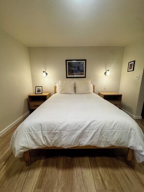 A bedroom with a large bed, two bedside tables, a framed picture on the wall, and wall-mounted lights. - Wine Country Ranch Retreat on a Working Horse Ranch (Santa Ynez)