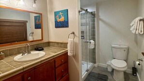 A bathroom with a double sink vanity, a glass shower enclosure, a toilet, and a mirror with artwork. - Ranch Retreat in Wine Country - Horses & Views! (Santa Ynez)