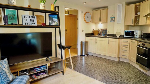 A modern kitchen with a TV, microwave, and cabinets.