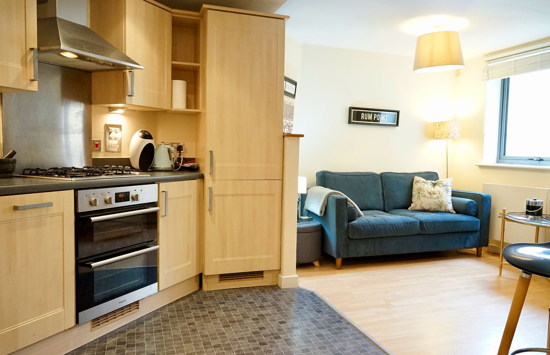 Une cuisine de taille réduite, équipée d’une cuisinière, d’un four et de meubles de rangement en bois.