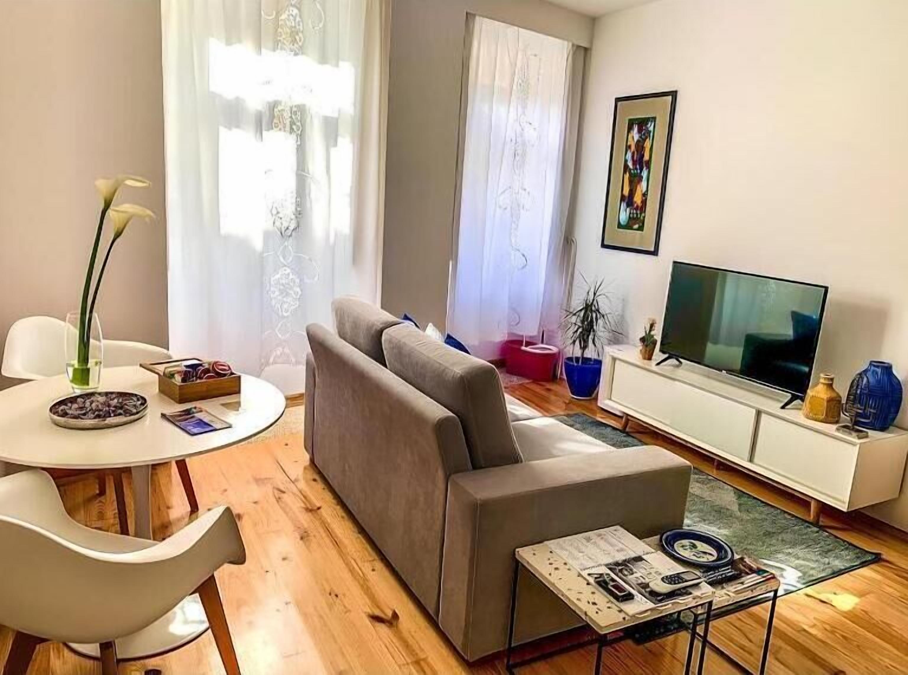 Un salon moderne avec un canapé, une table à manger et un téléviseur.