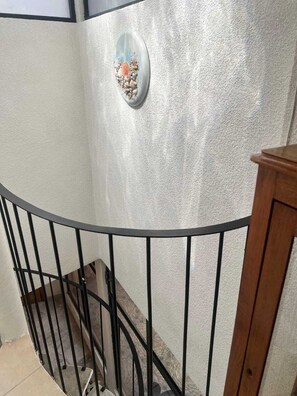 A staircase with a metal railing and a textured wall. - Charming Spacious Home in a Peaceful & Secure Gated Community, Mexico City (Ciudad de México)