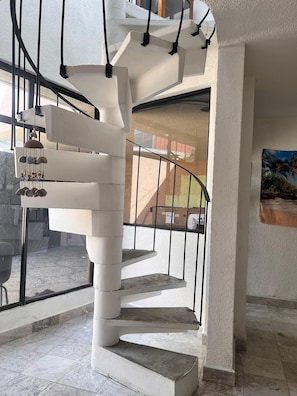 A spiral staircase with a metal railing, leading to an upper floor. - Charming Spacious Home in a Peaceful & Secure Gated Community, Mexico City (Ciudad de México)