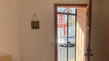 A room with a bench, a door leading outside, and a wall-mounted picture.