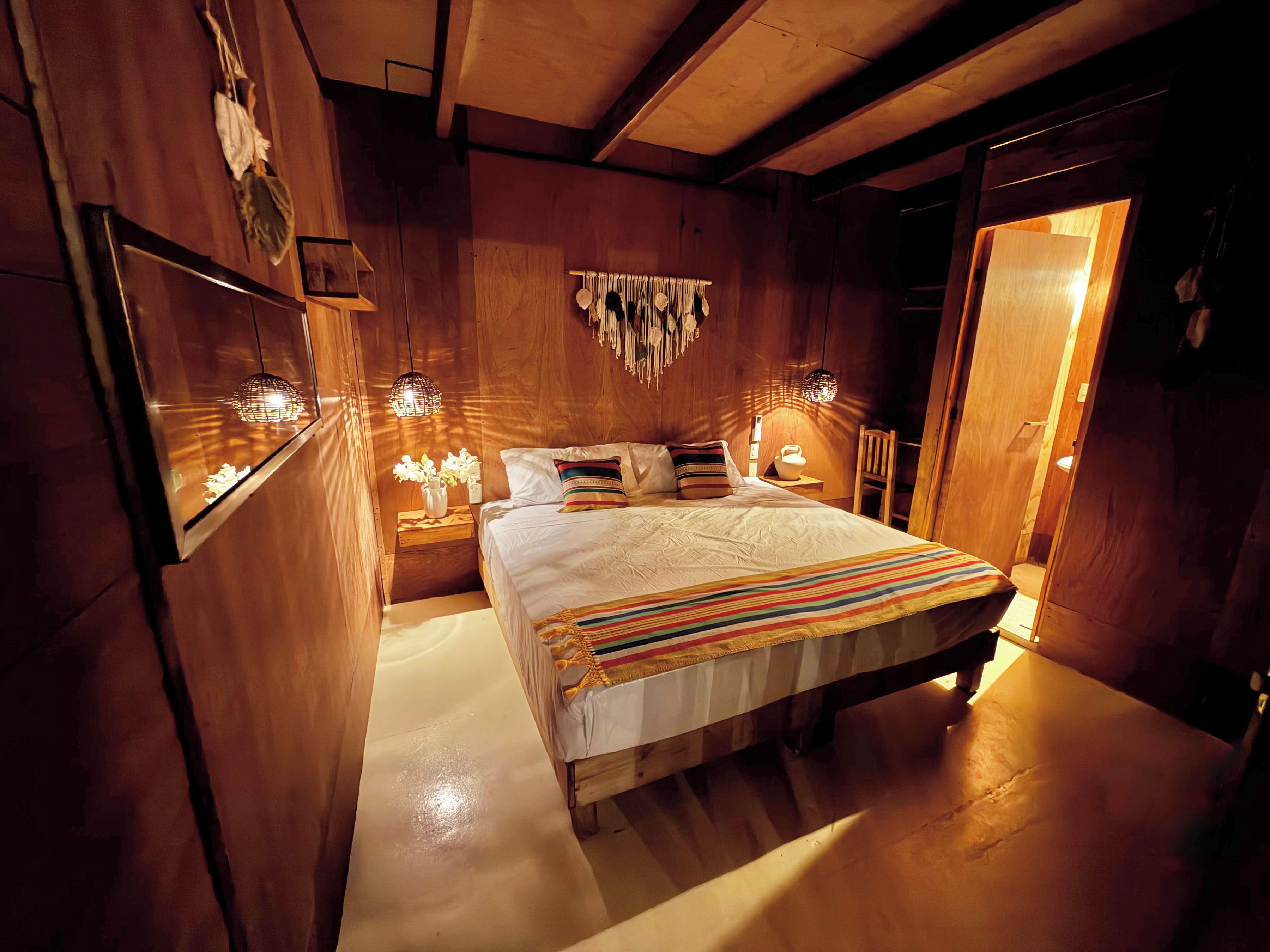 Une pièce en bois avec un lit, des tables de chevet et des éléments de décoration fixés au mur.