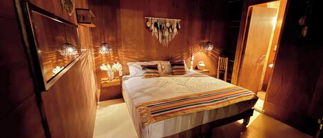 Une pièce en bois avec un lit, des tables de chevet et des éléments de décoration fixés au mur.