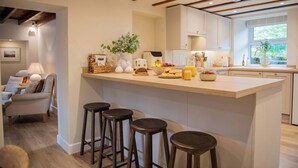 A modern kitchen with a central island, bar stools, and a breakfast bar.
