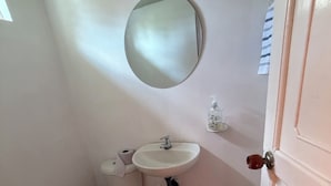 Une petite salle de bain avec des toilettes, un lavabo et un miroir.