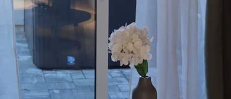 Taula rodona amb un llibre, una espelma i un ram de flors.