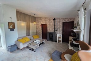 Un salon comprenant un canapé, une table basse, une cheminée et un mur en pierre.