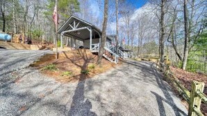 A rustic cabin with a covered porch and a staircase leading up to it, surrounded by trees. - Near Toccoa River • Hot Tub • Fire Pit • Gameroom - Holiday Home (Blue Ridge)