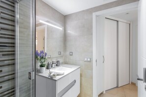 A modern bathroom with a glass shower enclosure, a white sink, and a mirror. - Sunset Star Holiday Home: Sea Views from Rooftop Solarium, Shared Terrace & Wi-Fi (Arguineguín)