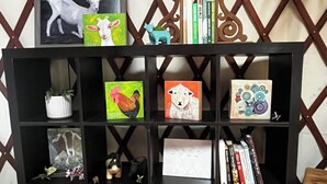 A black bookshelf with various items including framed artwork, books, and decorative objects. - Relax in a Cozy, Skylit Yurt at a Farm Animal Sanctuary (Pittsboro)