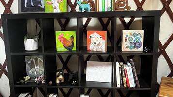 A black bookshelf with various items including framed artwork, books, and decorative objects.