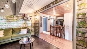 A cozy living area with a green sofa, a round coffee table, and a staircase with wooden railings.