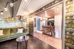 A cozy living area with a green sofa, a round coffee table, and a staircase with wooden railings.
