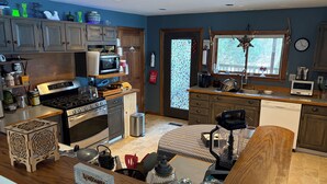 Una cocina moderna con armarios de madera, estufa a gas, microondas y lavavajillas.