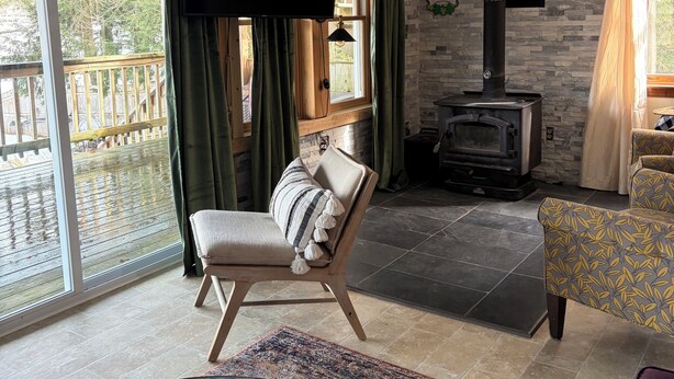 Una sala de estar con chimenea, televisión, sillón y sofá.