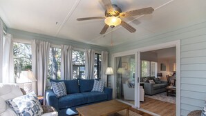 A living room with a blue sofa, a wooden coffee table, and a ceiling fan. - 764 Summerwind Villa | Peaceful Edisto Escape | Golf, Lagoon & Wildlife Views | Easy Beach Access (Edisto Beach)