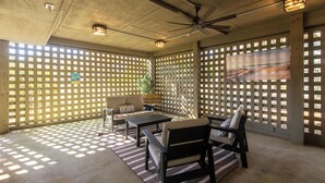 A covered patio area with a ceiling fan, a sofa, a table, and chairs. - 764 Summerwind Villa | Peaceful Edisto Escape | Golf, Lagoon & Wildlife Views | Easy Beach Access (Edisto Beach)