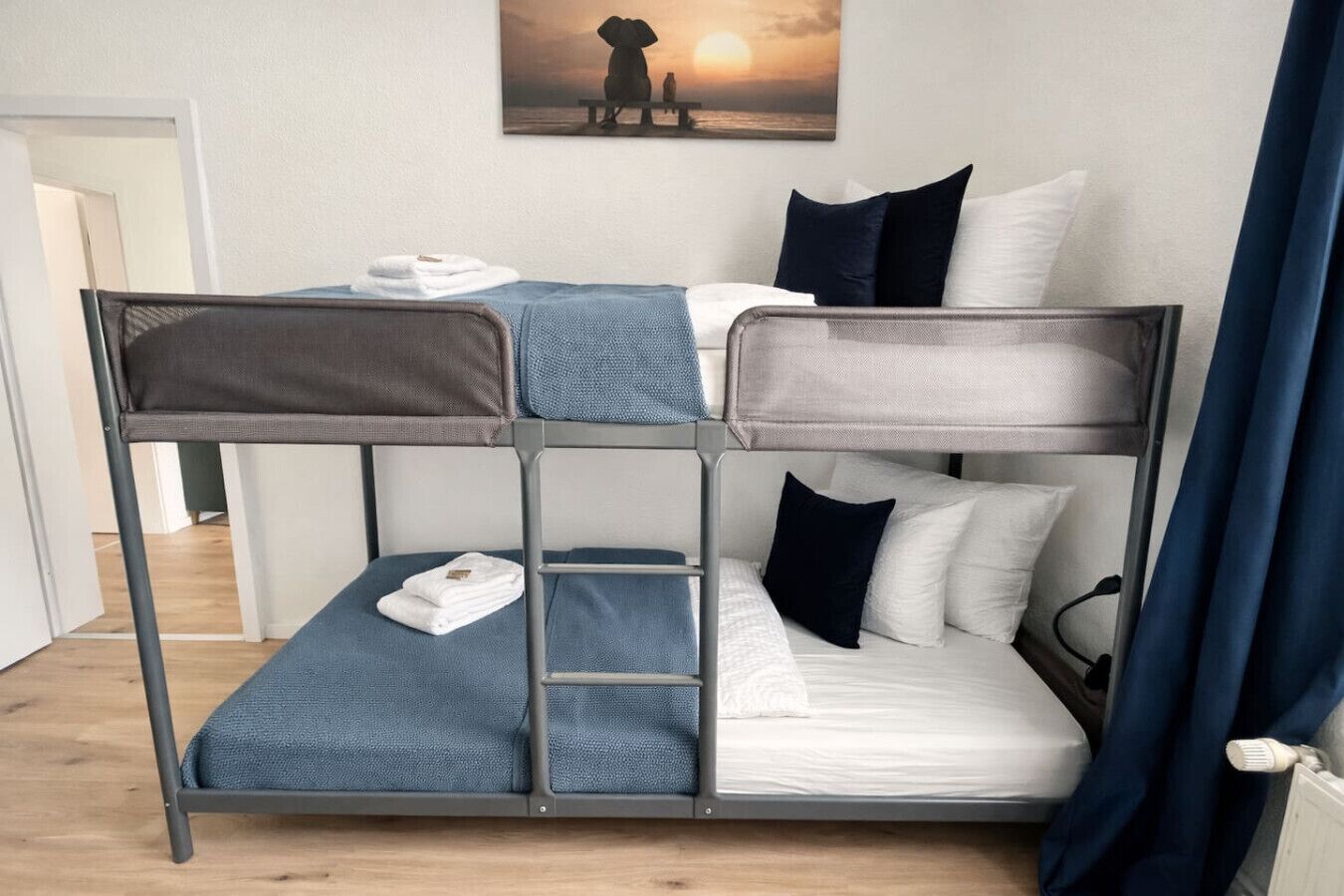 A bunk bed with a view of the sunset through a window.