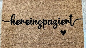 Un paillasson avec le texte « hereinpazient » et un petit symbole en forme de cœur.