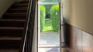 Een trap die leidt naar een glazen deur, uitgevend op een tuin.