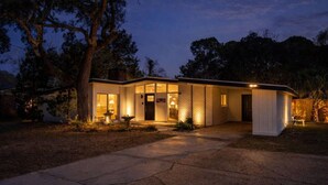 A modern house with a well-lit entrance, large windows, and a visible garage. - Pool + Hot Tub Retreat · Sleeps 18 · Near Destin (Fort Walton Beach)