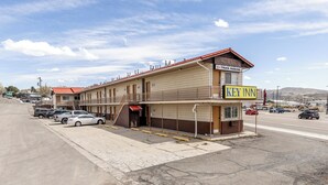 Motel amb un rètol de 'Key Inn', zona d'aparcament de camions i filera d'habitacions al llarg d'un carrer.