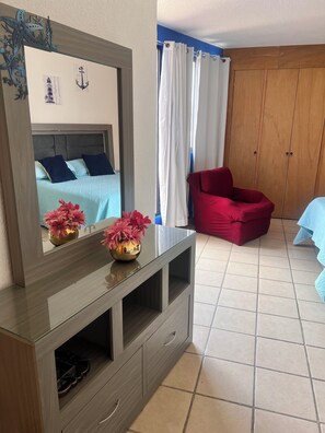 A bedroom with a bed, a dresser, a mirror, a red chair, and a wardrobe. - A pearl in the city beautiful and comfortable house in a safe and secure area with 24 hour security. (Ciudad de México)