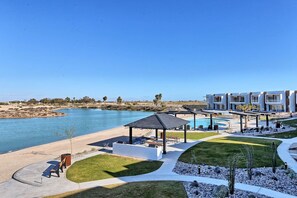 Ein Resort mit Pool, Außenbereich und Blick auf das Wasser.