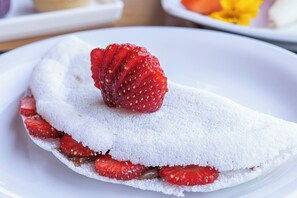 A dessert with a white base, strawberries, and a dusting of powdered sugar. - Pousada Vereda da Serra (Pirenopolis)