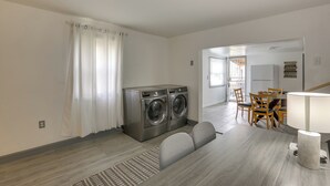 A modern apartment with a dining area, a washing machine, and a kitchen. - Work, Relax & Explore The 'Burgh! McKeesport Home (McKeesport)