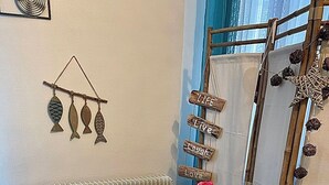 Un comedor con una mesa de madera dispuesta para cuatro personas, un radiador y una pared decorada con un pez y un letrero que dice 'Live Laugh Love'.