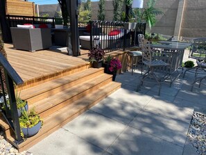 A wooden deck with outdoor furniture, including a sofa and chairs, and a table.
