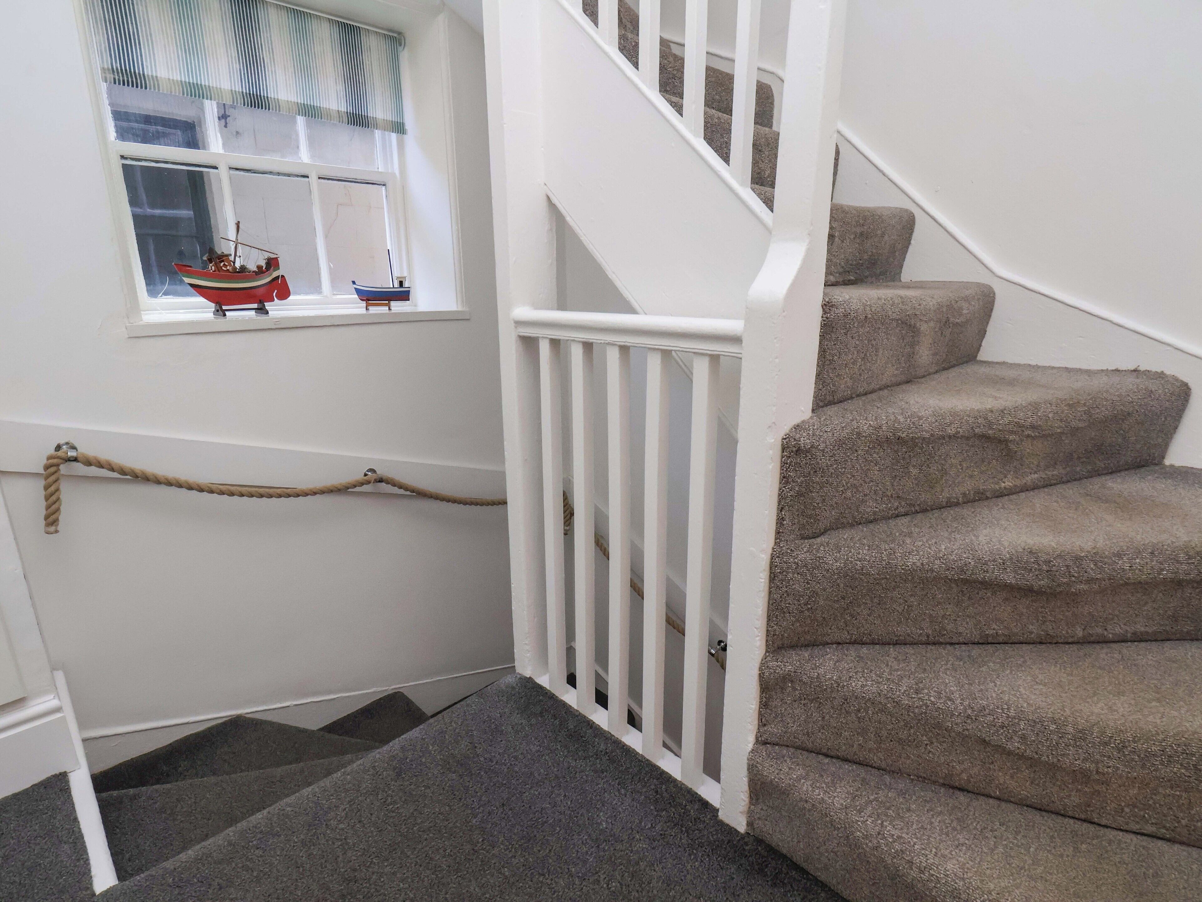 A staircase with carpeted steps and a white railing.