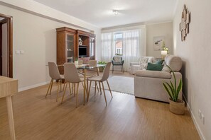 A modern living room with a dining area, a sofa, and a television. - Apartment 'Sérénité' with Balcony, Wi-Fi and Air Conditioning (Ponta Delgada)