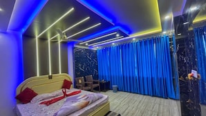 Een moderne slaapkamer met een bed, gordijnen en een plafondventilator.