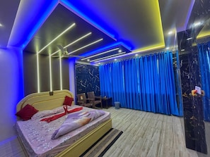A modern bedroom with a bed, curtains, and a ceiling fan. - Hotel aj plaza (Mayapur)