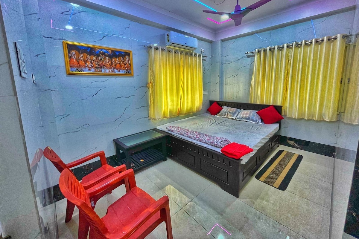 A bedroom with a bed, curtains, a ceiling fan, and a small table.
