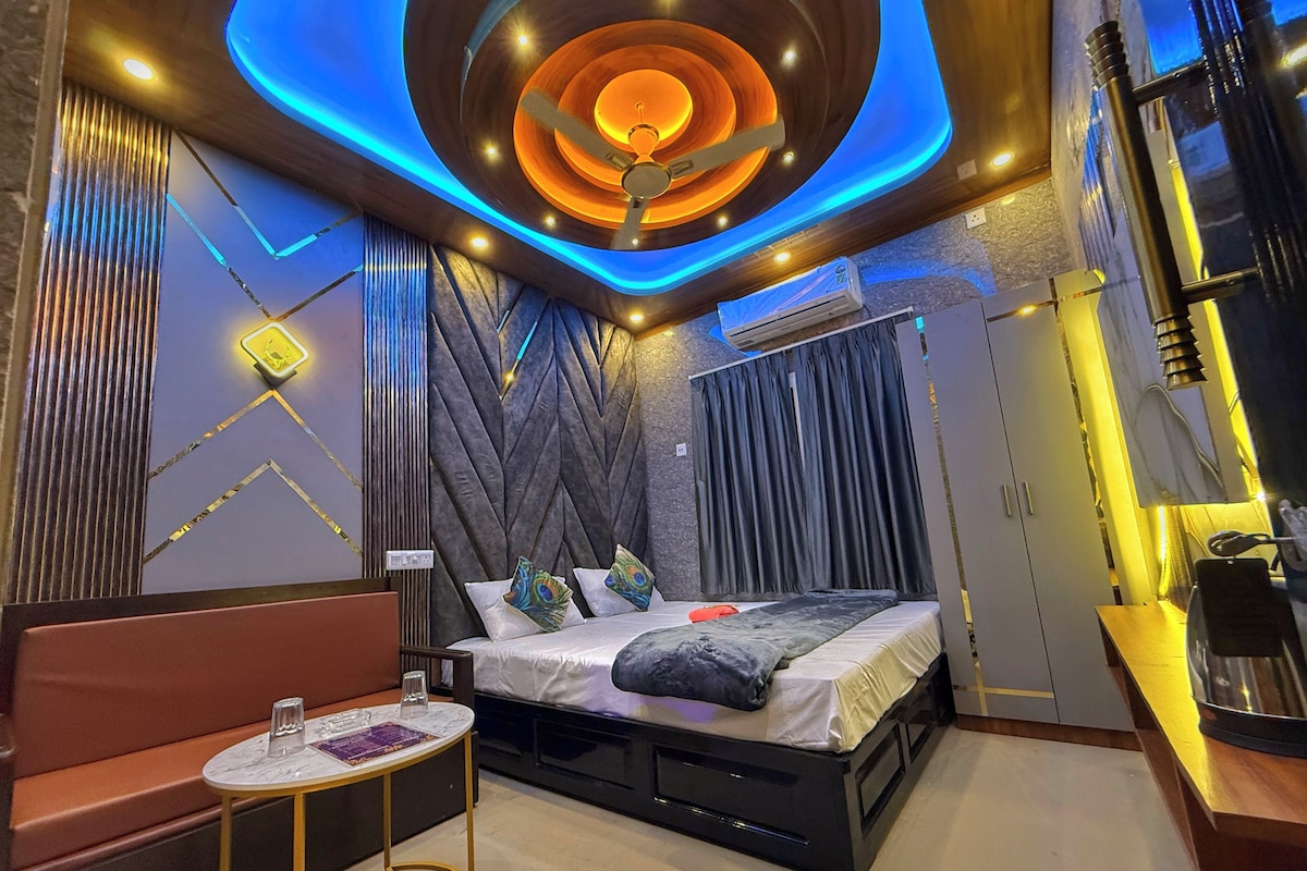 A modern bedroom with a bed, a small table, and a sofa.