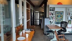 Een moderne keuken met een koelkast, kookplaat en een eethoek met tafel en stoelen.