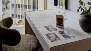 A modern hotel room with a large window, a white countertop, a chair, a mirror, and a potted plant. - A Stone Studio Beside Chapultepec (Ciudad de México)