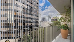 A high-rise building with a balcony featuring a potted plant. - A Stone Studio Beside Chapultepec (Ciudad de México)