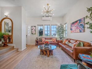 Ein geräumiges Wohnzimmer mit einem Glastisch, Ledersofas und einem großen Fenster mit Blick.