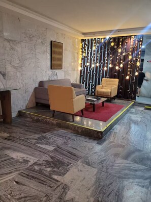 A modern living room with marble flooring, two sofas, a coffee table, and a decorative wall with string lights. - Cozy Apartment on the Beach (Fortaleza)