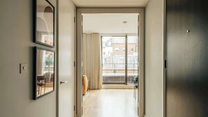 Ein Flur, der zu einem Balkon mit Blick auf Gebäude führt.